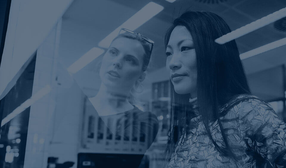 Two colleagues looking at whiteboard