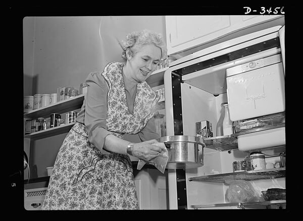 A woman putting cooked food in the refrigerator (U.S. Office for Emergency Management, 1942).