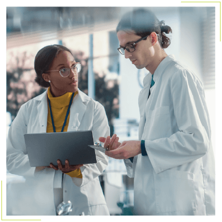 Two female professionals in white lab coats discussing talent solutions for CDMOs.