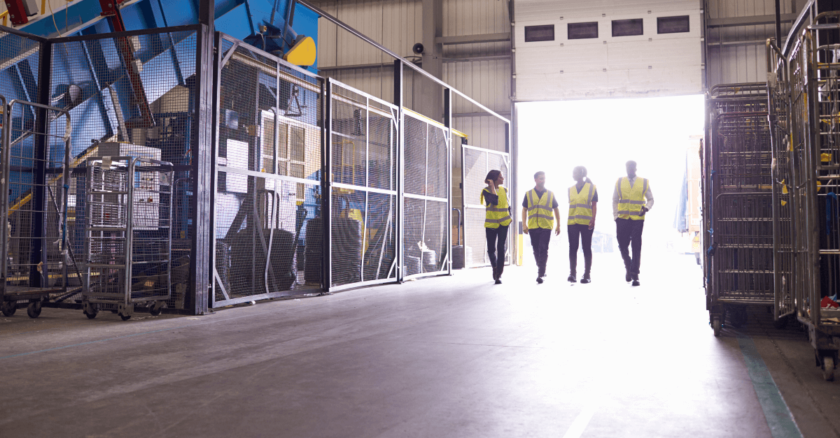 Workers wearing yellow vests walk into warehouse