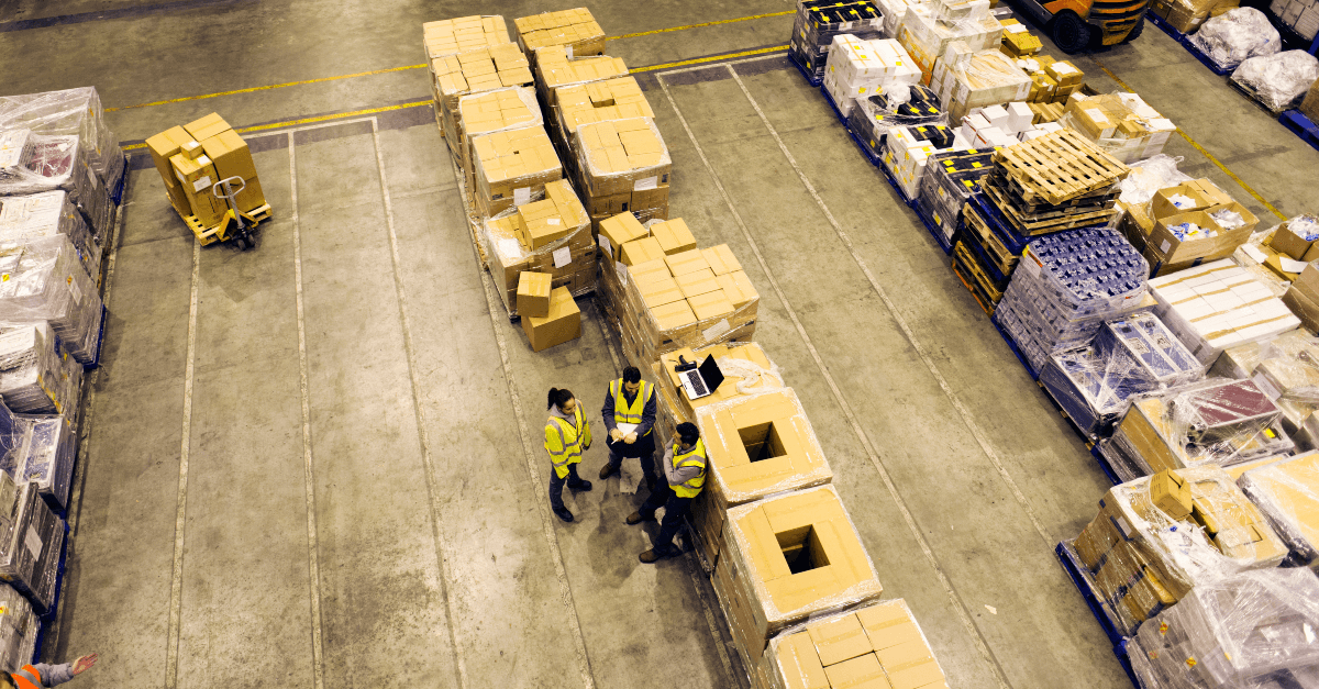 An overhead shot of three workers talking to each other on a production floor