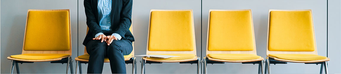 a person sitting down in a row of yellow chairs