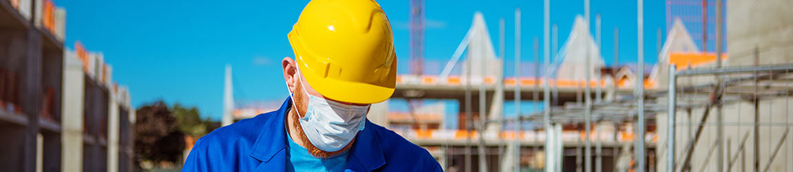 Ouvrier de la construction portant un casque protecteur et un masque