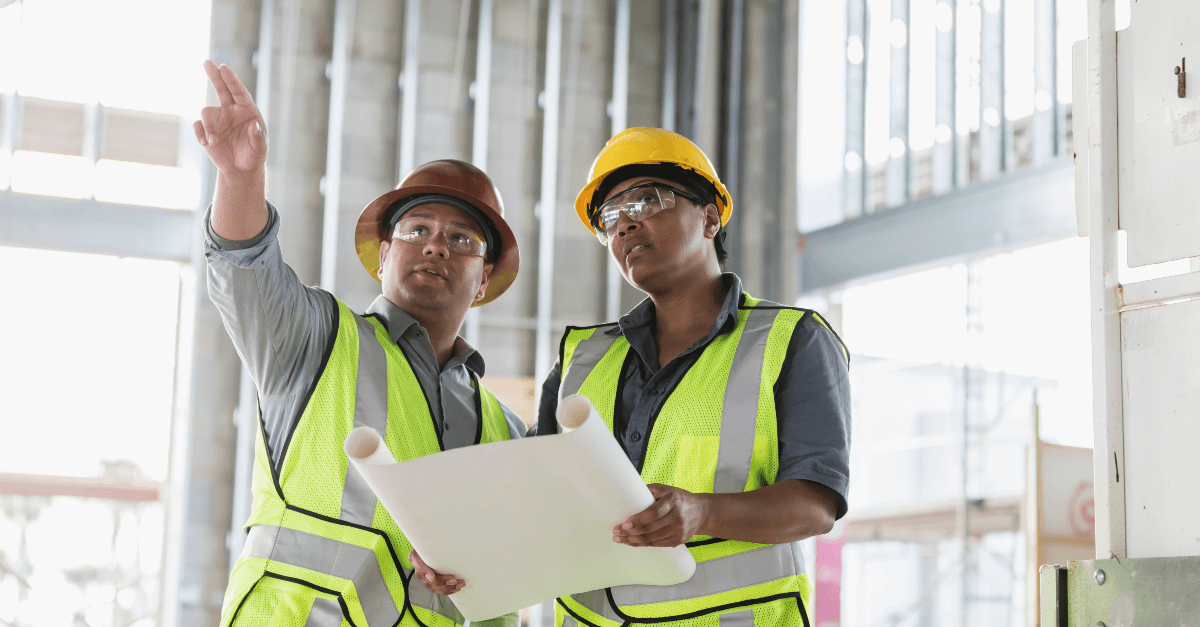 Two construction workers looking at blueprints
