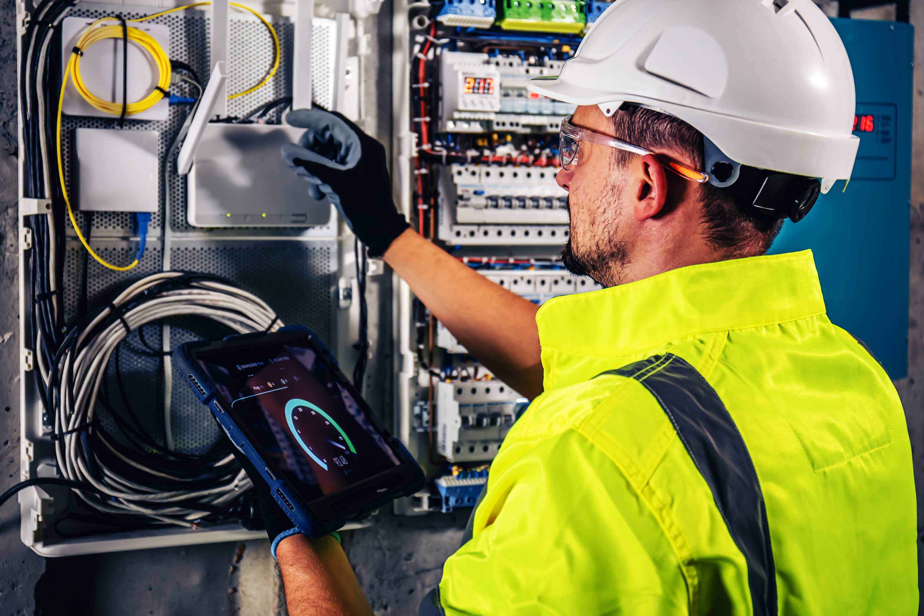 Industrial maintenance technician uses digital technology and connected equipment to perform electrical system monitoring and troubleshooting.