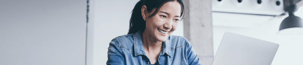 une femme souriante travaillant sur son ordinateur portatif