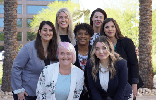Seven Aston Carter women employees posing for a group photo.