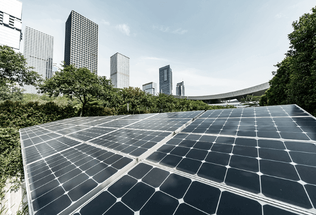 Angled view of solar panels and building in the background.