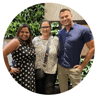 Three Aston Carter employees smile at an event
