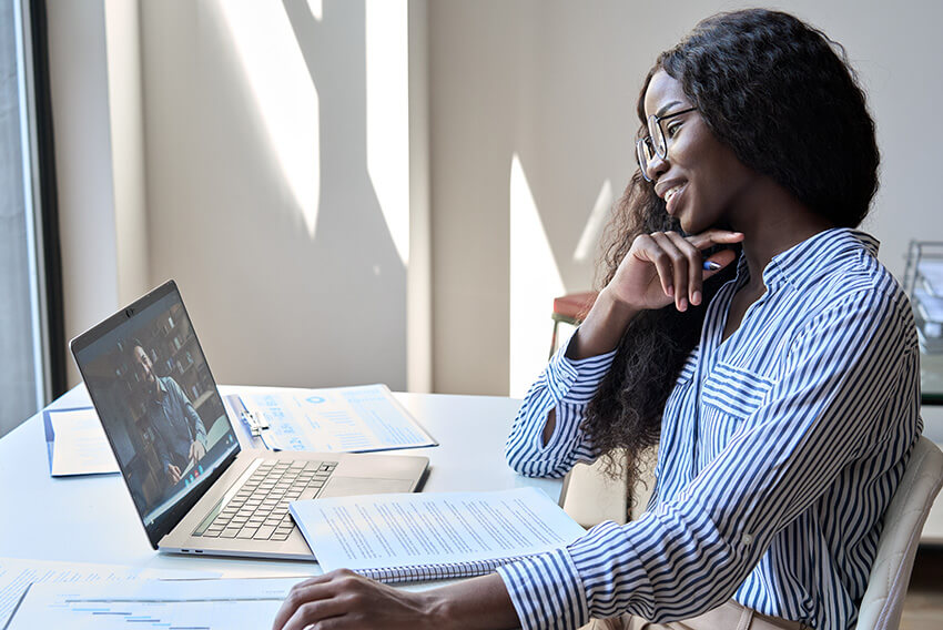 Woman takes video call from laptop