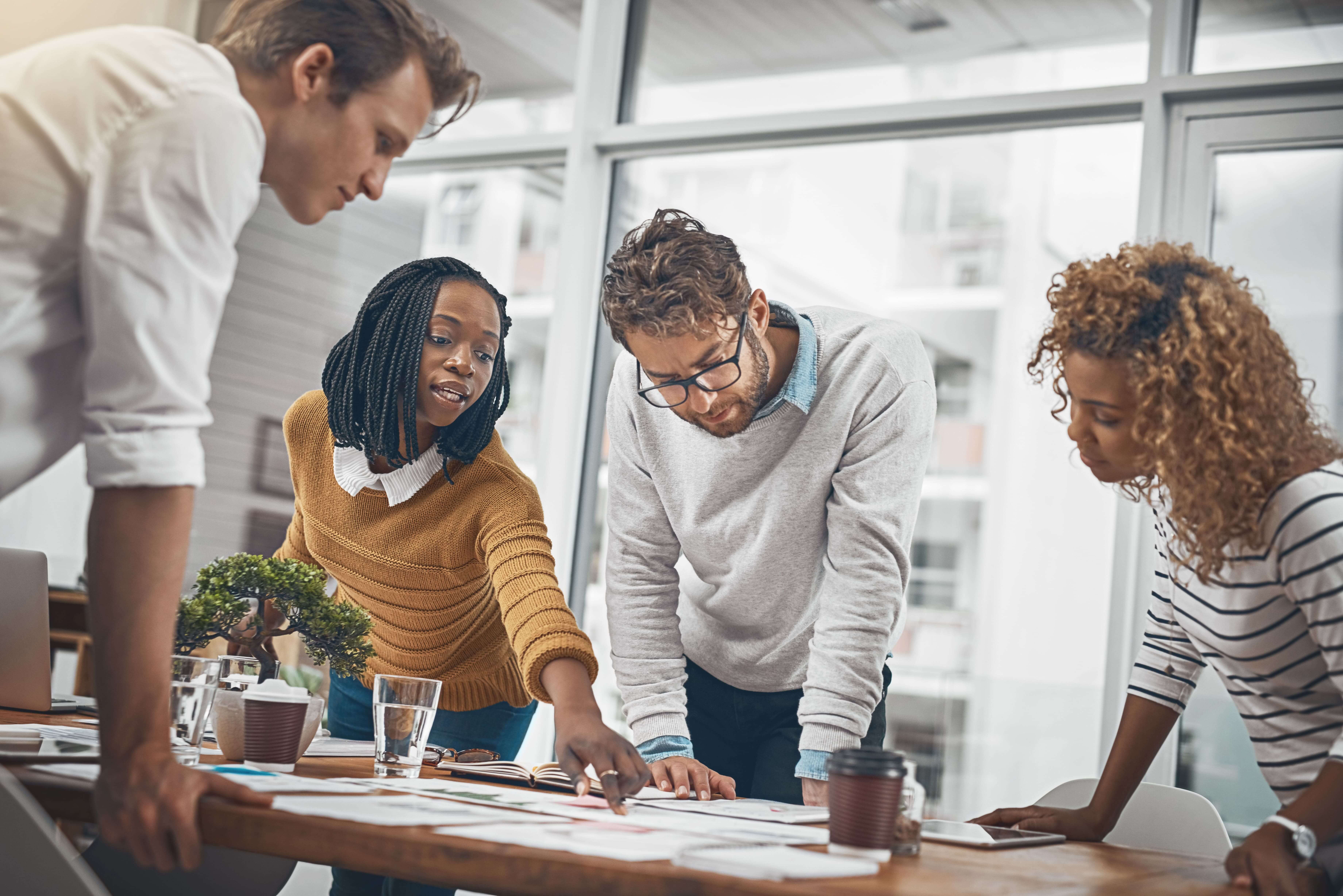 A diverse group of employees gathered around a conference room table