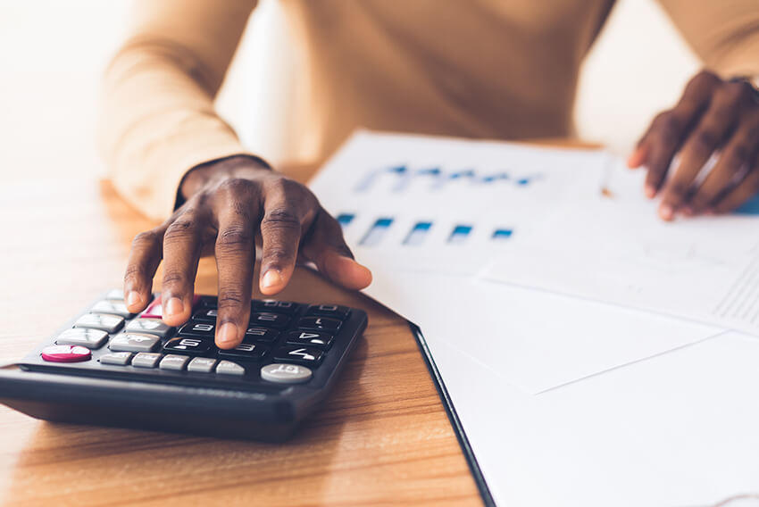 Business professional using calculator for reports