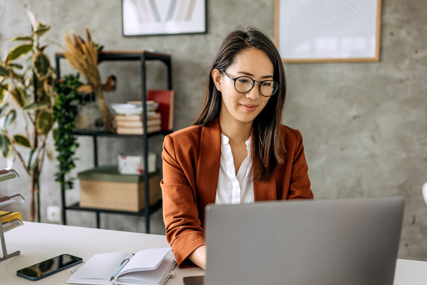 A female administrative professional reading about how AI and automation is redifining administrative roles.