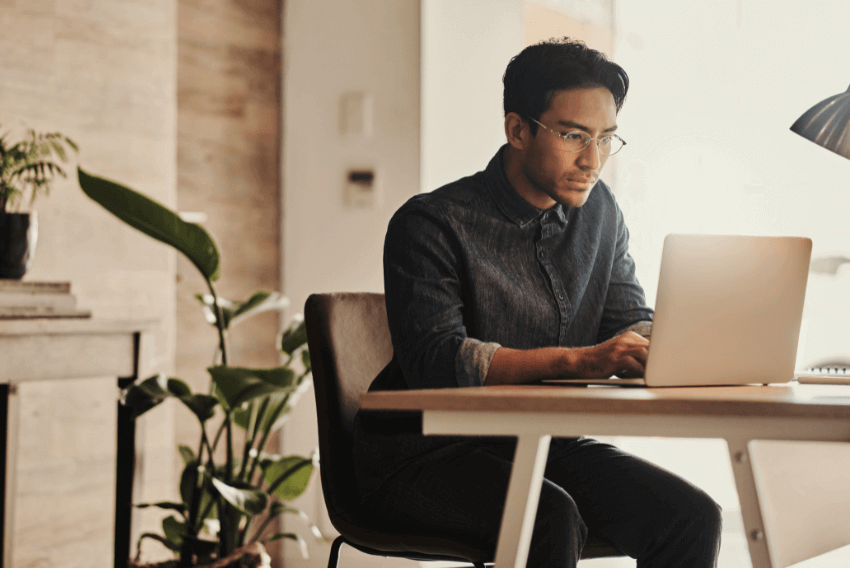 A male searching on his laptop reasons why digital upskilling is essential for administrative workers in 2024.