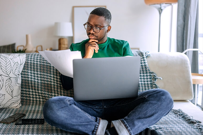 Male job seeker trying to find a job by searching job sites on his laptop.