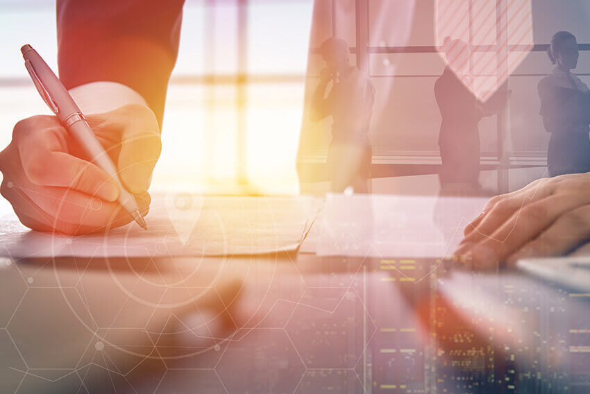 Une personne écrivant avec un stylo alors que le soleil brille en arrière-plan. Articles sur le recrutement d’Aston Carter