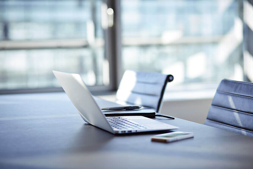  A computer and mobile phone on a table. Aston Carter Recruitment Articles.