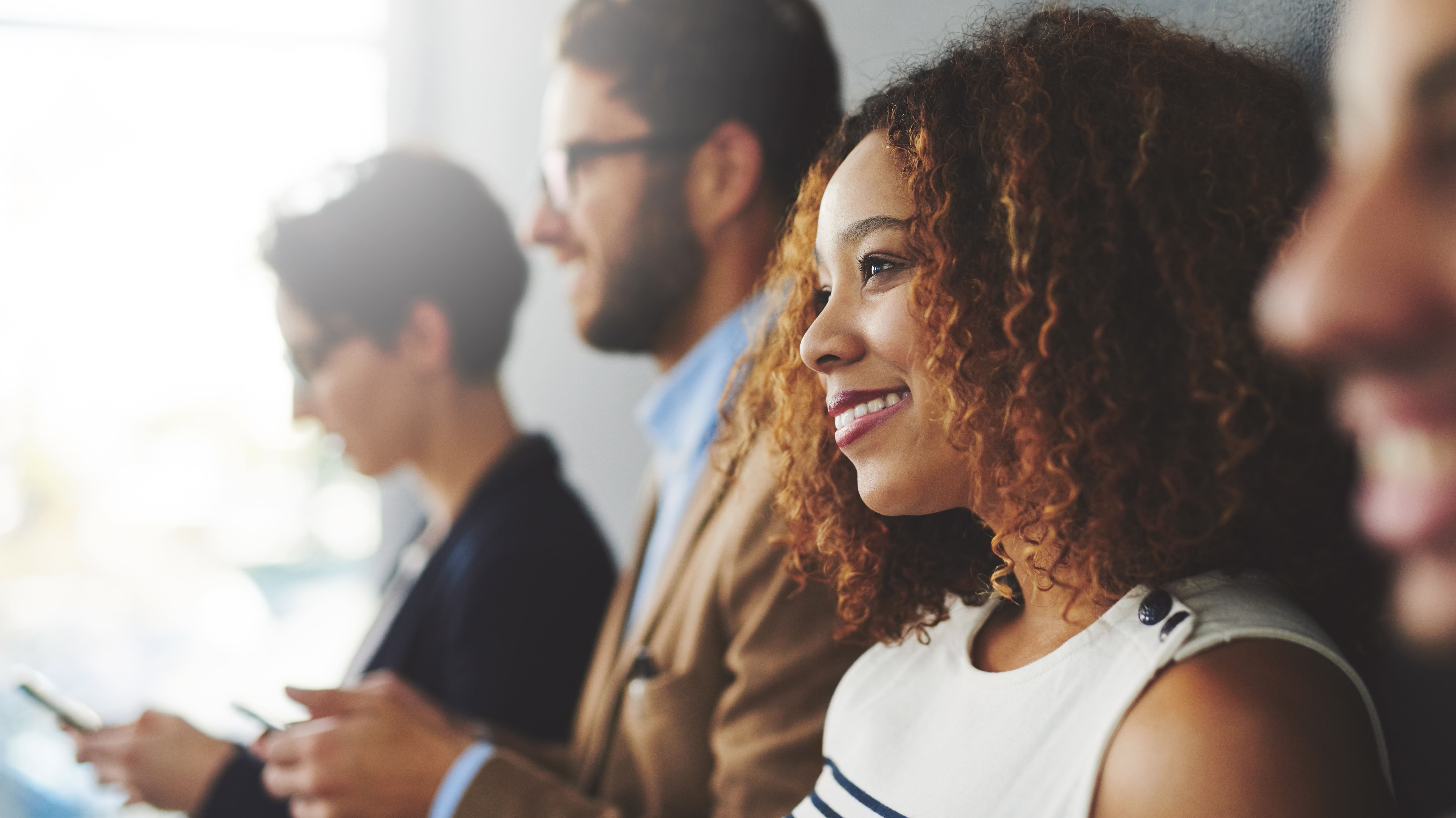 Black female employee smiling during business meeting or lecture