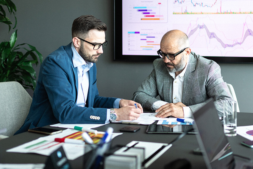 Male professional is working with a client to drive cost savings following an expedited vendor analysis due to impact on tariffs.