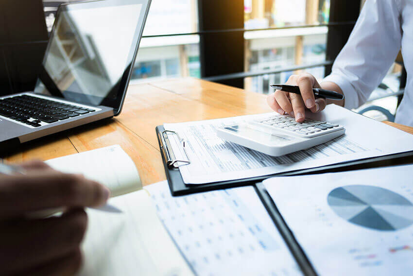 Two professionals working together on reports and calculations. 