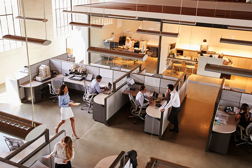 Overhead view of a professionals working at their desks and other office duties.  Aston Carter Recruitment Articles.