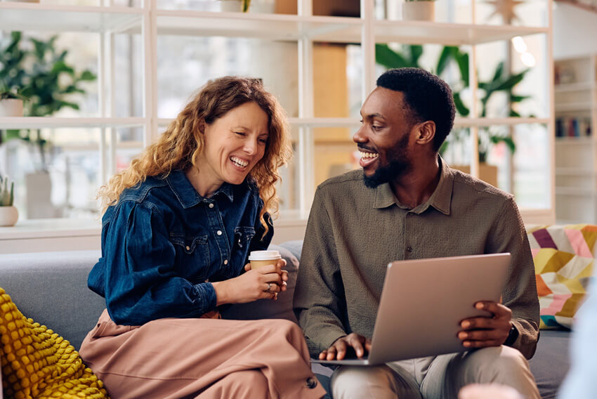 Male and female professionals reviewing the Canadian labour market report on a laptop looking at Q1 2026 market trends.