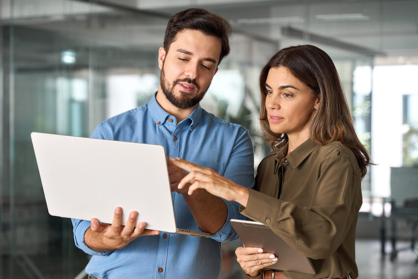 Two coworkers reviewing the quarterly Canada labour market and economy report on a laptop looking at Q3 2025 trends.