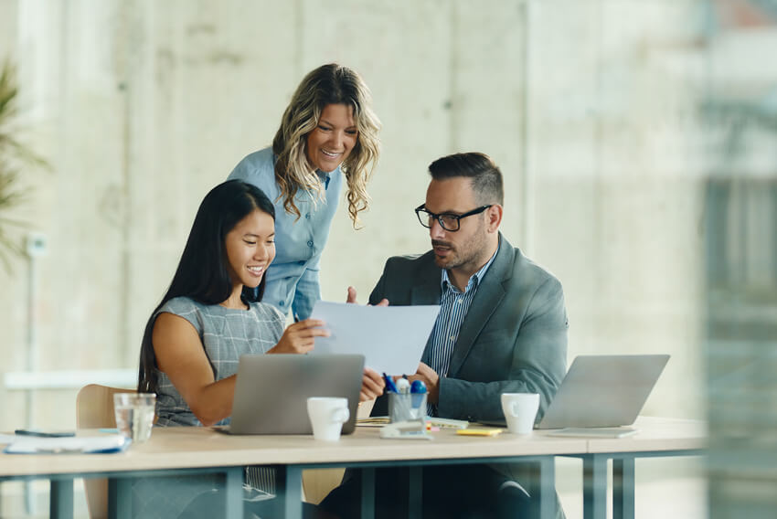 A group of coworkers reviewing the August 2025 jobs reporting looking at July 2025 labor market and economy trends.