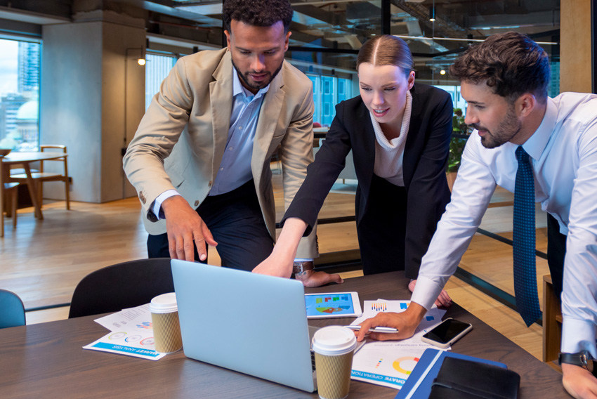 Men and female professionals review June 2024's jobs report looking at May's labor market trends.