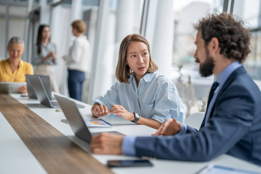 Male and female coworkers reviewing the June 2026 jobs report on a laptop looking at May labor market and economy trends.