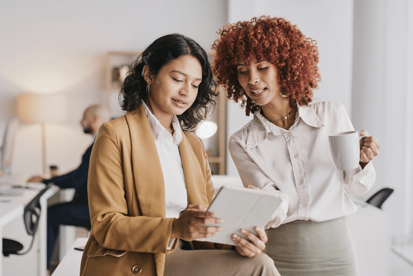Two women reviewing the December 2023 jobs report.