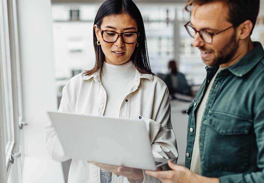 A man and woman reading the June 2023 jobs report for labor market trends.