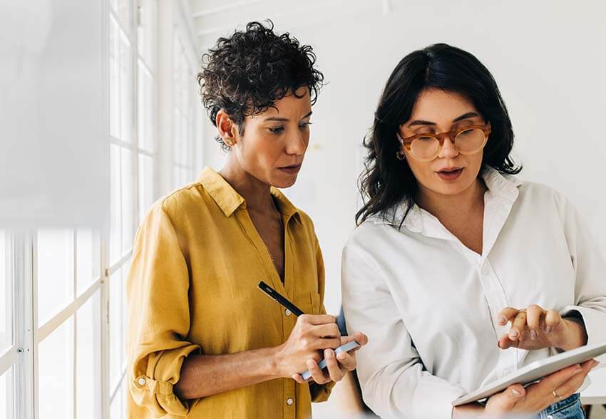 Two woman reviewing the March 2023 labor market analysis.