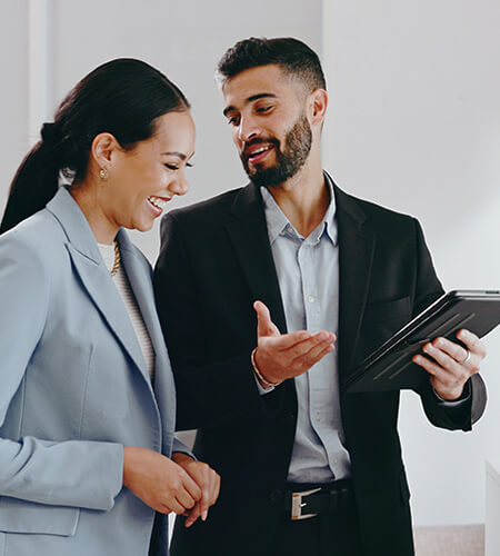 Male and female coworkers discuss how tariffs will affect business transformation and automation.