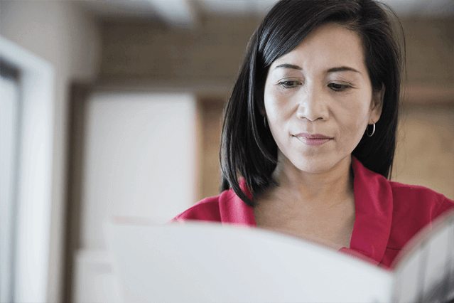 Professional woman looking at an open booklet.