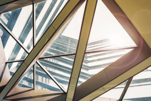View of building through a glass window, with angled architecture of the building.