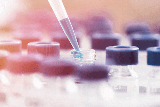 Eye-dropper with liquid inside, used to fill small, glass vials.