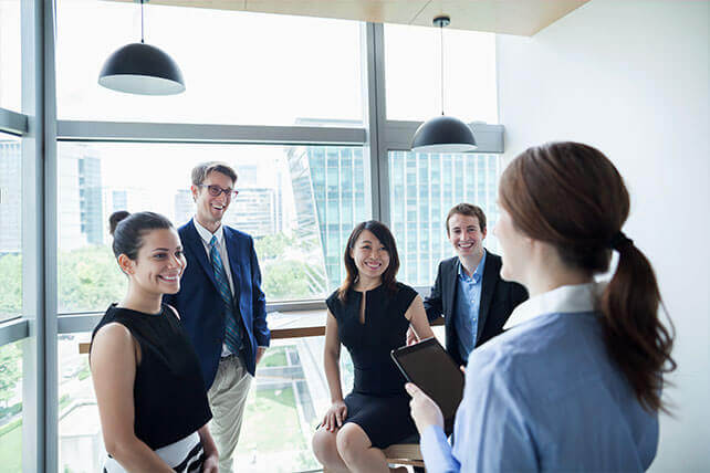 Aston Carter Services Business Disciplines Account and Finance. Diverse group of men and women discussing a business acheivement.
